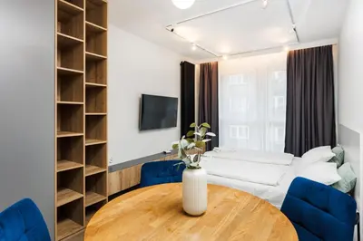 a living room with a table and blue chairs at City of the Kings-Szmaragd in Kraków