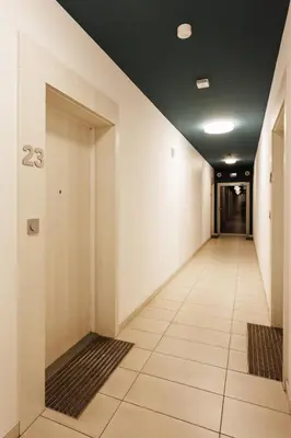 a hallway of an office with a door and a tile floor at City of the Kings-Szmaragd in Kraków
