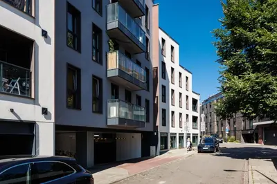 a car parked on a street next to a building at City of the Kings-Szmaragd in Kraków