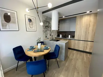 a kitchen and dining room with a table and blue chairs at City of the Kings-Szmaragd in Kraków