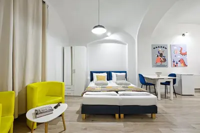 a bedroom with a bed and a table and chairs at Urban Nest Apartments Szewska 21-R in Kraków