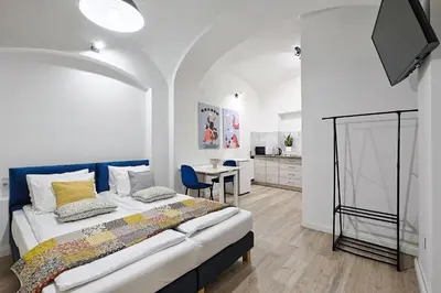 a bedroom with a large bed and a table at Urban Nest Apartments Szewska 21-R in Kraków