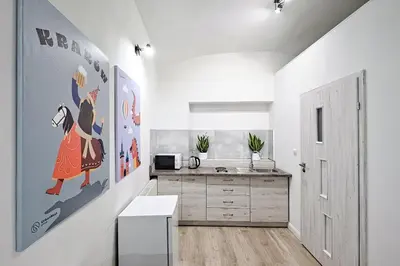 a white kitchen with a sink and a counter at Urban Nest Apartments Szewska 21-R in Kraków