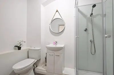 a white bathroom with a toilet and a mirror at Urban Nest Apartments Szewska 21-R in Kraków