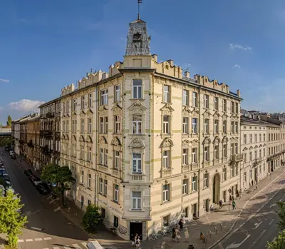 a yellow building with a tower on top of it at Happy Tower in Kraków