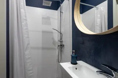 a bathroom with a shower and a sink and a mirror at Barbacan Suites - Old Town Apartments - by Upstairs in Kraków