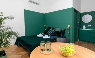 a room with a bed and a table with a bowl of fruit at Barbacan Suites - Old Town Apartments - by Upstairs in Kraków