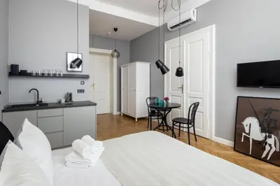a bedroom with a bed and a kitchen with a table at Barbacan Suites - Old Town Apartments - by Upstairs in Kraków