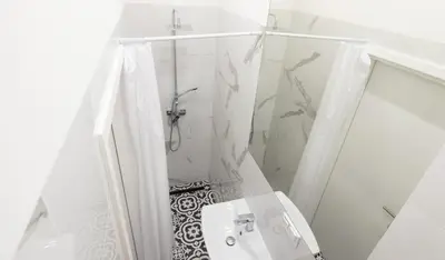 a white bathroom with a shower and a toilet at Barbacan Suites - Old Town Apartments - by Upstairs in Kraków