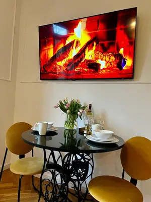 a black table with chairs and a fireplace at Krakow Old Town Apartment Jacuzzi - wymeldowanie do 13 in Kraków