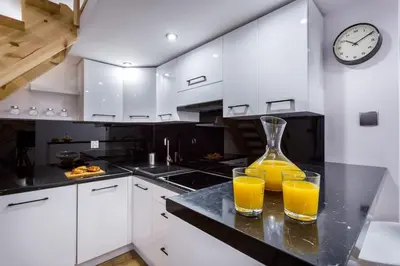two glasses of orange juice on a counter in a kitchen at Cozy Stay Apartment - Kazimierz in Kraków