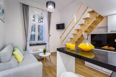 a living room with a couch and a staircase at Cozy Stay Apartment - Kazimierz in Kraków