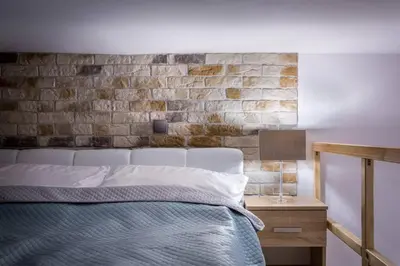 a bedroom with a bed and a brick wall at Cozy Stay Apartment - Kazimierz in Kraków
