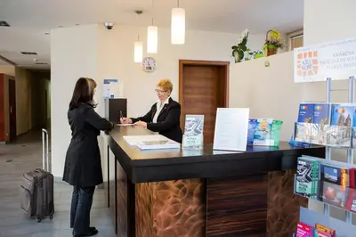 a man and a woman standing at a counter at Dom Turystyczny Indigo in Kraków
