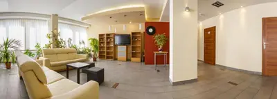 a lobby with couches and a tv in a building at Dom Turystyczny Indigo in Kraków