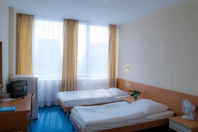 a hotel room with two beds and a television at Dom Turystyczny Indigo in Kraków