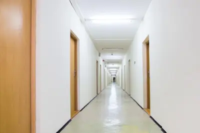 an empty corridor of an office building with white walls and ceilings at Dom Turystyczny Indigo in Kraków