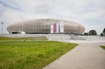 a large building in a field next to a grass field at Dom Turystyczny Indigo in Kraków