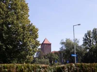 a building with a tower in the distance with trees at Apartment Quiet Street 11, 3E in Oświęcim