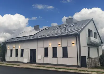 a white building with a black roof at Apartment Quiet Street 11, 3E in Oświęcim
