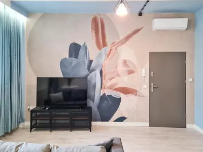 a living room with a tv and a mural on the wall at Apartment Quiet Street 11, 3E in Oświęcim