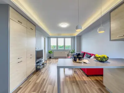 a kitchen with a table and a living room at Apartament z widokiem na panoramę miasta in Kraków