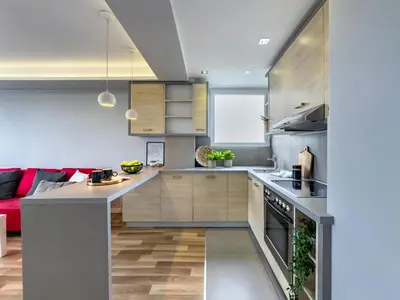 a kitchen with wooden cabinets and a red couch at Apartament z widokiem na panoramę miasta in Kraków