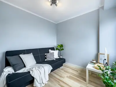 a bedroom with a black bed with white pillows at Apartament z widokiem na panoramę miasta in Kraków