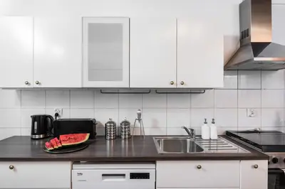 a kitchen with white cabinets and a sink at Urok Centrum: Podwójne Piękno in Kraków