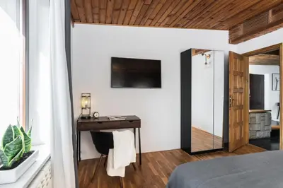 a bedroom with a desk and a television on a wall at Urok Centrum: Podwójne Piękno in Kraków