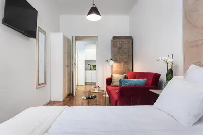 a bedroom with a bed and a red couch at Urok Centrum: Podwójne Piękno in Kraków