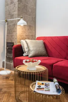 a living room with a red couch and a table at Urok Centrum: Podwójne Piękno in Kraków