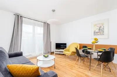 a living room with a couch and a table and chairs at Modern Apartments with FREE parking spots in Kraków
