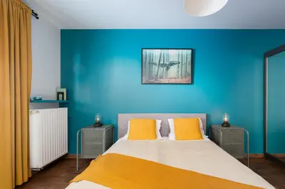 a blue bedroom with a bed with yellow pillows at Modern Apartments with FREE parking spots in Kraków