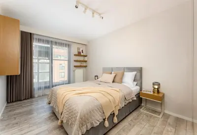 a bedroom with a large bed and a large window at Modern Apartments with FREE parking spots in Kraków