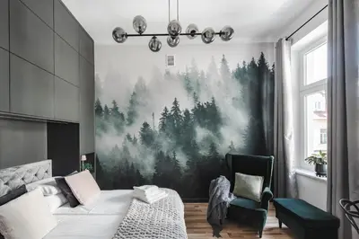 a bedroom with a large painting of trees on the wall at Copernicus House in Kraków