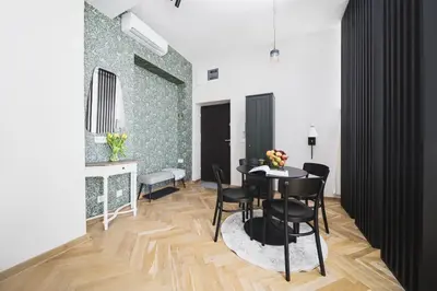a dining room with a table and black chairs at Copernicus House in Kraków