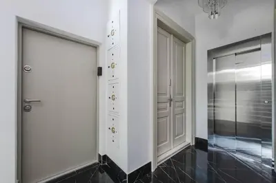 a walk in closet with white doors and a black tile floor at Copernicus House in Kraków
