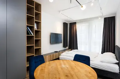 a room with a bed and a wooden table at City of the Kings- Szafir in Kraków