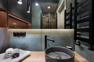 a bathroom with a sink and a tub with towels at City of the Kings- Szafir in Kraków