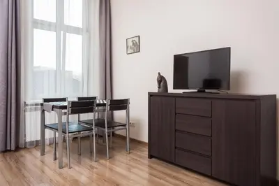 a living room with a tv and a table and chairs at Luxor in Kraków