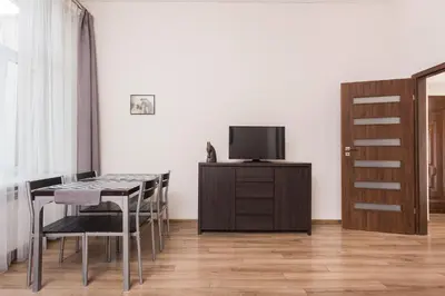 a dining room with a table and a tv on a cabinet at Luxor in Kraków