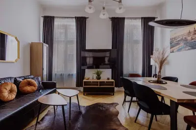a living room with a black couch and a table at Golden Pearl - Main Square, 100 sqm, 4 rooms in Kraków