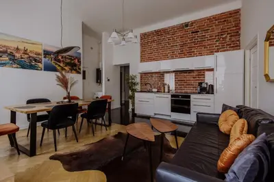 a living room with a couch and a table and a kitchen at Golden Pearl - Main Square, 100 sqm, 4 rooms in Kraków