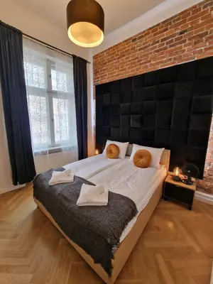 a bedroom with a large bed with a brick wall at Golden Pearl - Main Square, 100 sqm, 4 rooms in Kraków