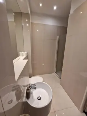 a white bathroom with a sink and a shower at Golden Pearl - Main Square, 100 sqm, 4 rooms in Kraków