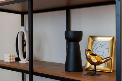 a shelf with a black vase and a picture at Cozy Corner by Cozyplace in Kraków