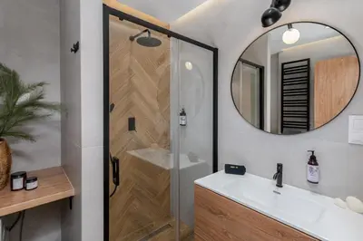 a bathroom with a shower and a sink and a mirror at Cozy Corner by Cozyplace in Kraków