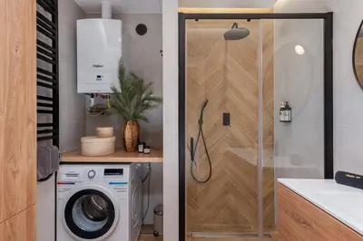 a bathroom with a washing machine and a shower at Cozy Corner by Cozyplace in Kraków