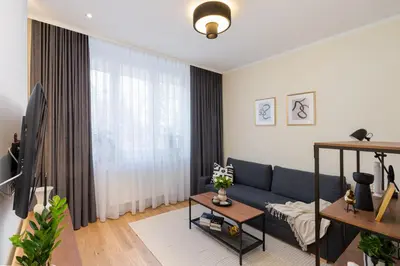 a living room with a blue couch and a tv at Cozy Corner by Cozyplace in Kraków